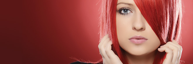 Woman with red hair standing in front of red background